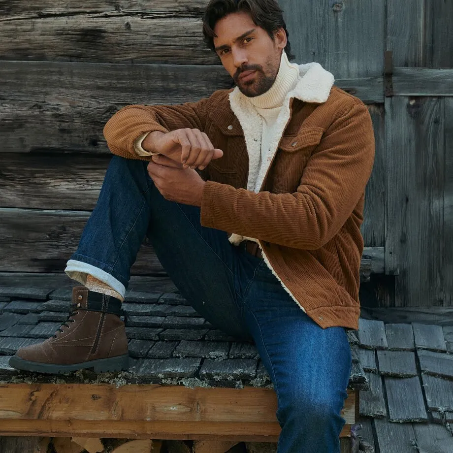 Veste chaude en velours c&ocirc;tel&eacute;, pull &agrave; col roul&eacute; cr&egrave;me, jean et bottes d'hiver robustes.