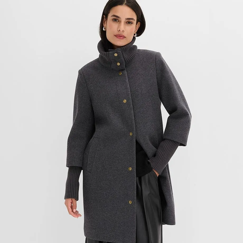 Manteau court gris &eacute;l&eacute;gant &agrave; col haut, boutons dor&eacute;s et manches c&ocirc;tel&eacute;es.