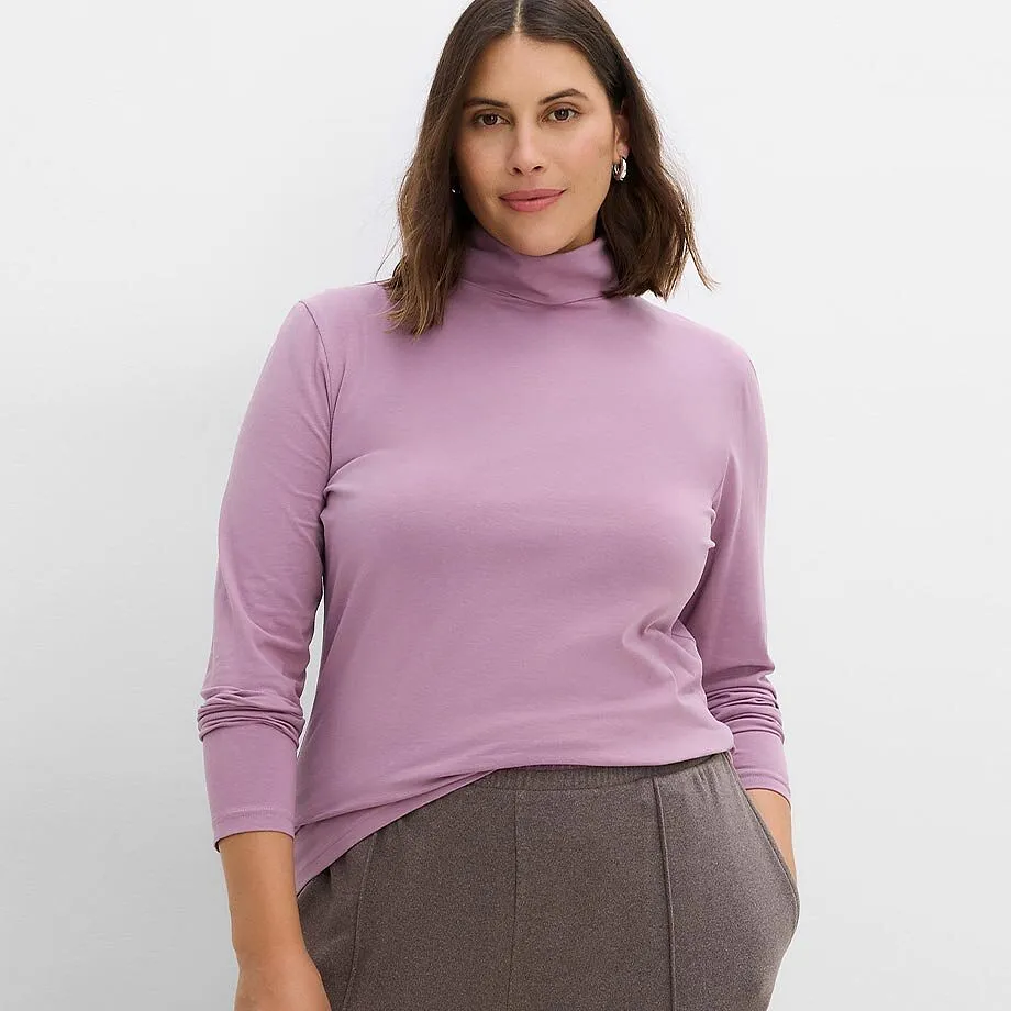 Elegantes lila Rollkragen-Shirt kombiniert mit einer weichen, dunkelbraunen Hose.