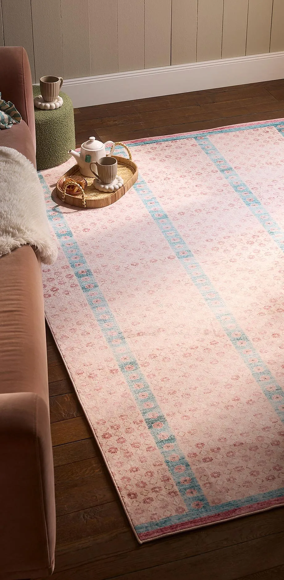 Un tapis raffin&eacute; rose &agrave; rayures bleues d&eacute;core le sol.