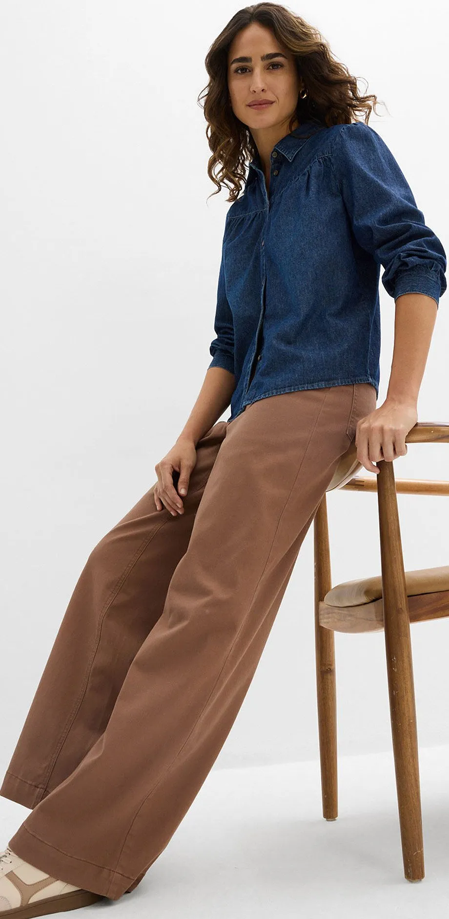 Chemisier en jean bleu fonc&eacute; associ&eacute; &agrave; un pantalon marron et des tennis claires.