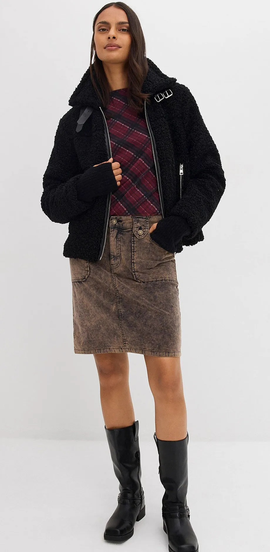 Veste noire, pull &agrave; carreaux, jupe en velours c&ocirc;tel&eacute; marron et bottes.