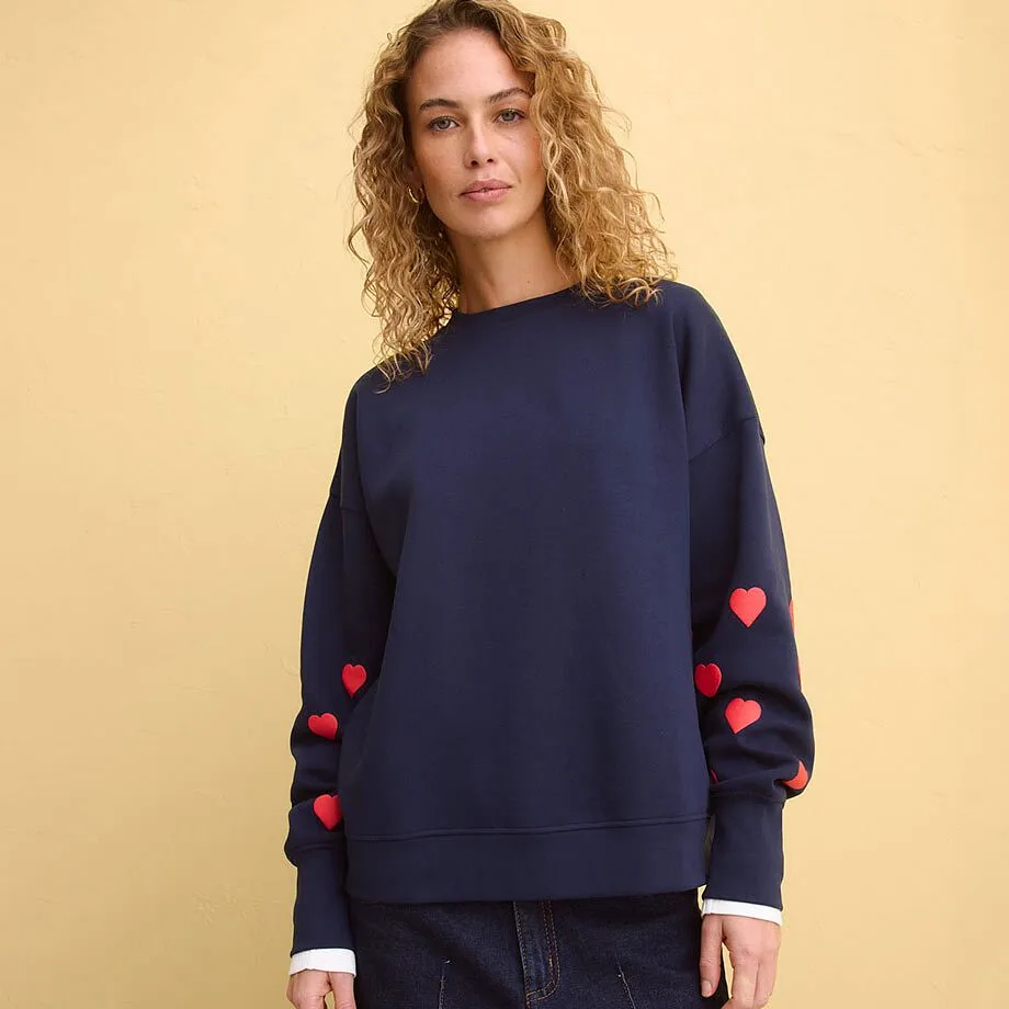 Sweat-shirt bleu fonc&eacute; avec applications c&oelig;urs rouges sur les manches.