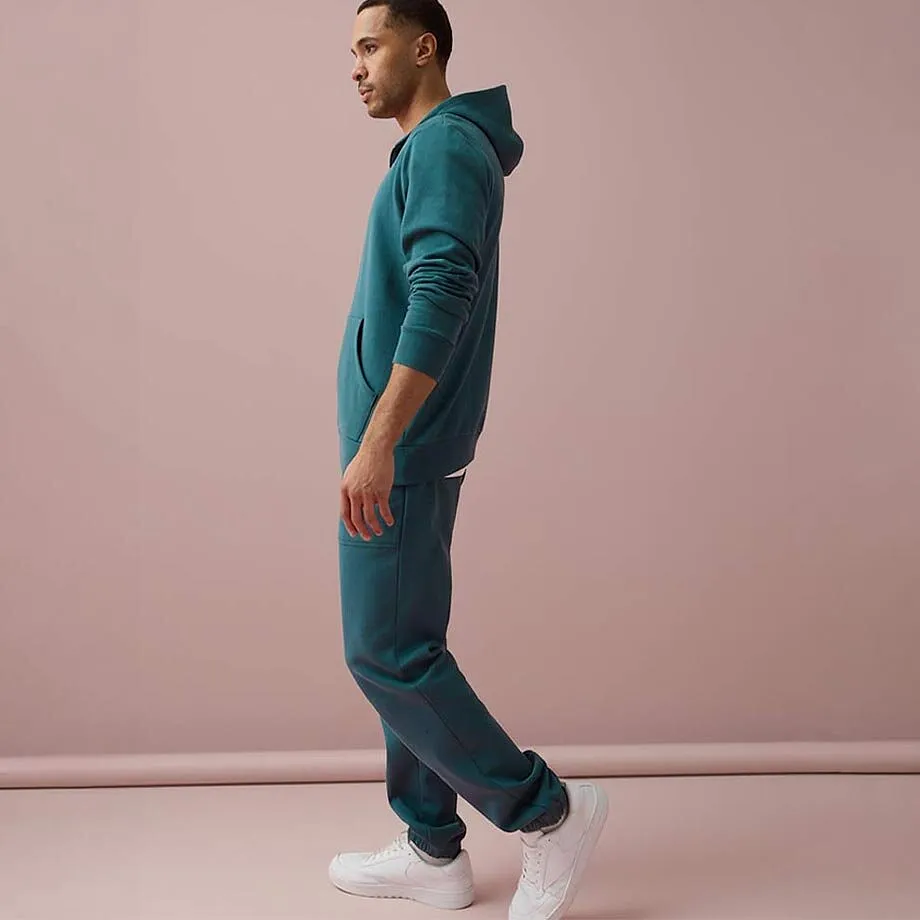 Surv&ecirc;tement bleu turquoise avec fermeture zipp&eacute;e et sneakers blanches.