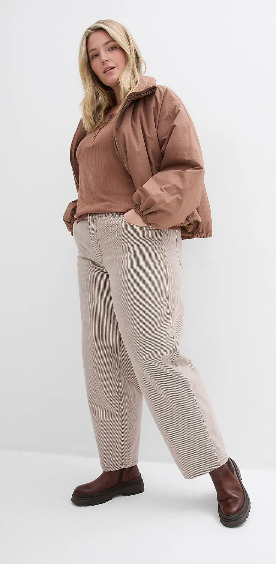 Veste et top marron, pantalon beige et chaussures marron fonc&eacute;.