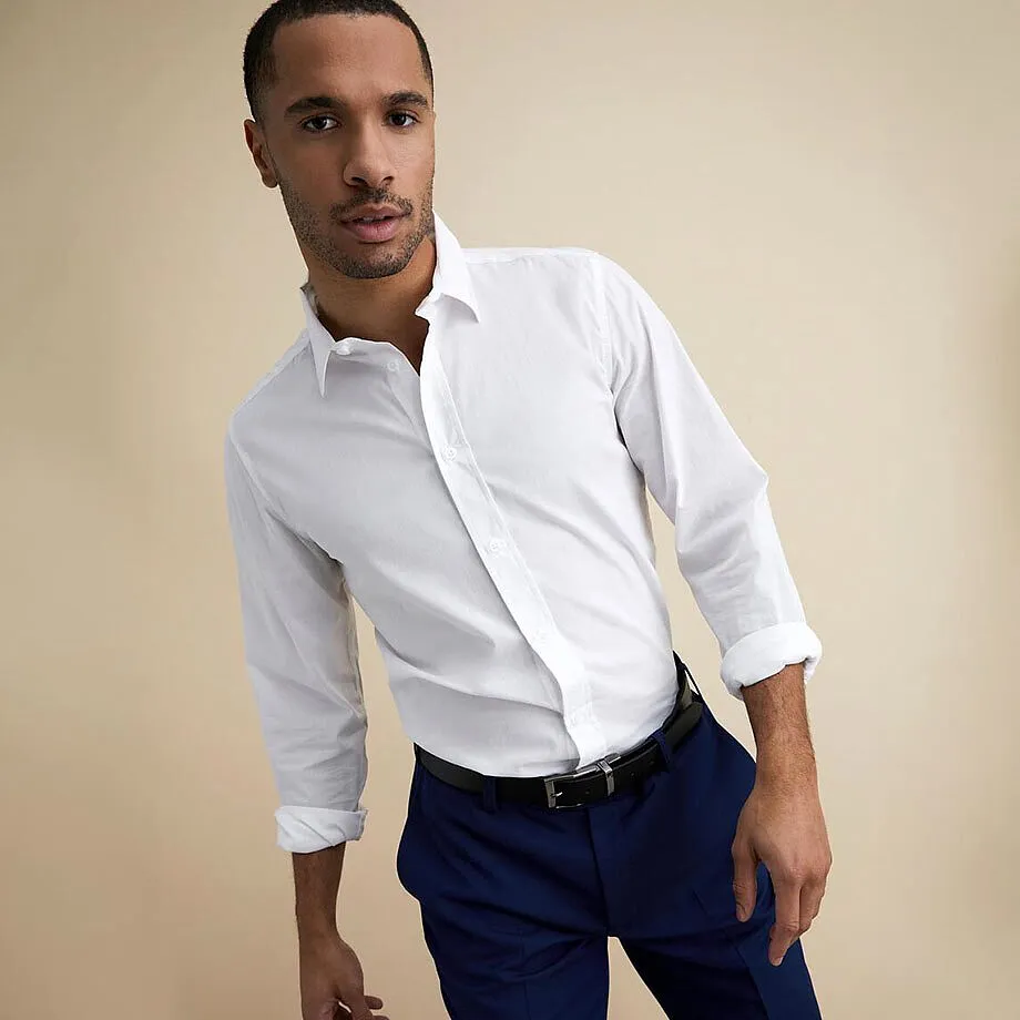 Chemise blanche &eacute;l&eacute;gante et pantalon bleu fonc&eacute;.