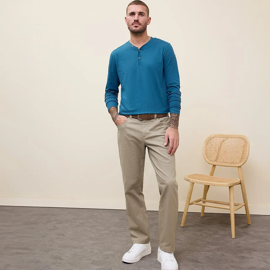 Chemise bleue &agrave; manches longues, pantalon chino beige et baskets blanches.