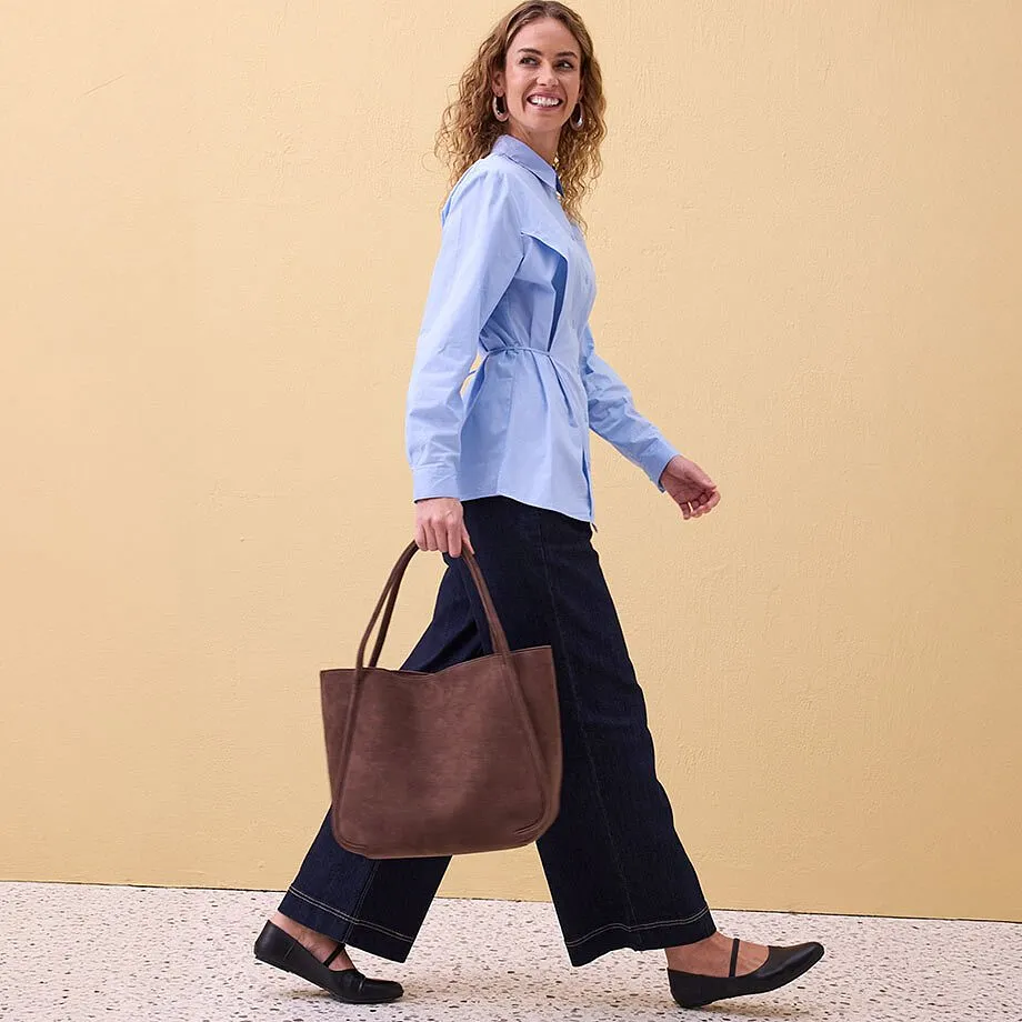 Chemisier clair, pantalon large de couleur fonc&eacute;e et ballerines.