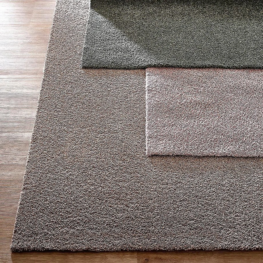 Weiche Teppiche in verschiedenen Erdt&ouml;nen: Gr&uuml;n, Beige und Rosa.